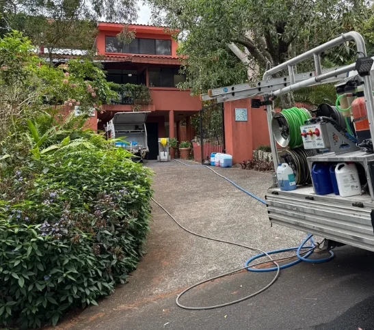 Xterior Power Clean gutter vacuum truck set up outside a home, hoses run to the roof