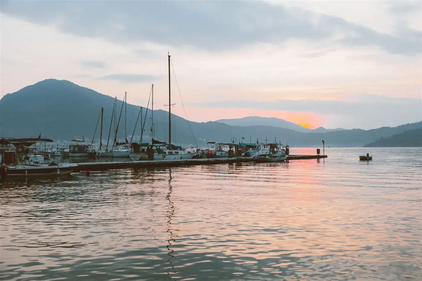 Boats moored along a jetty on the water
