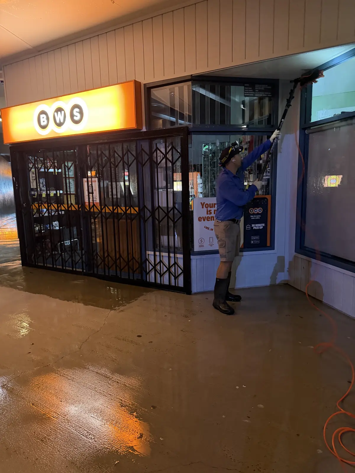 Xterior Power Clean technician cleaning a shopfront awning overnight at Sunrise Beach