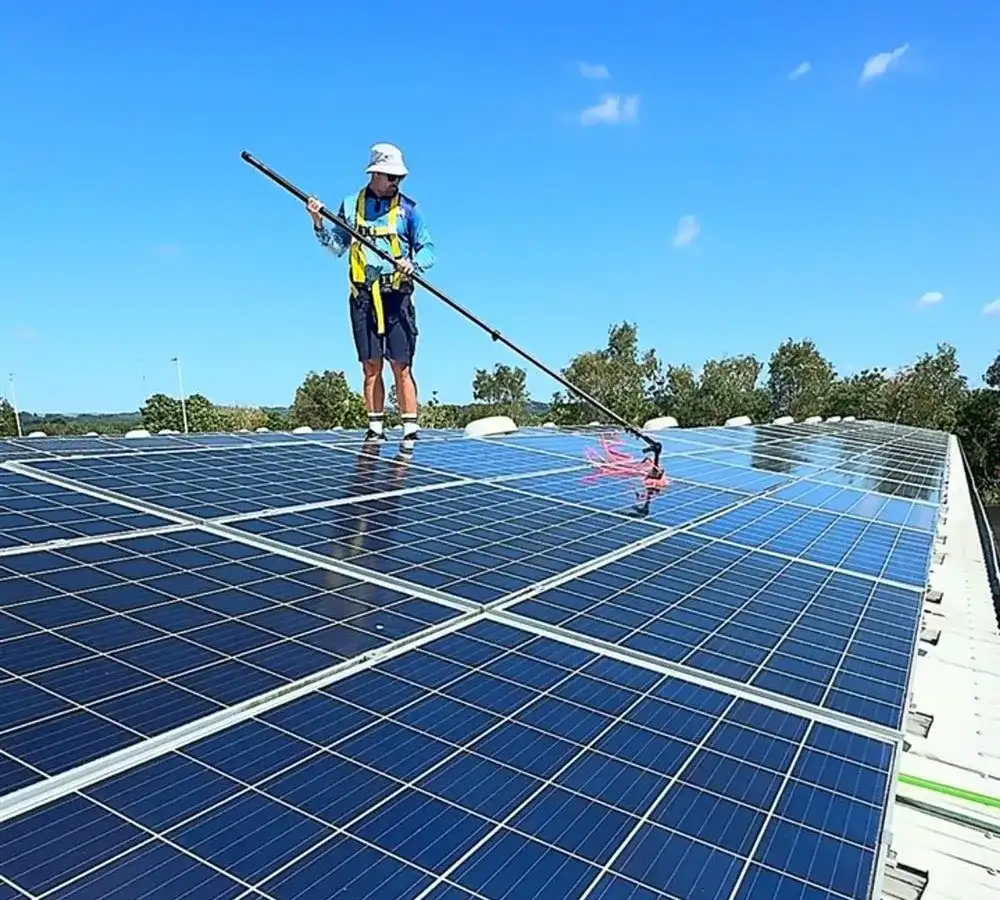 Justin from Xterior Power Clean using a water-fed pole to clean a commercial solar array